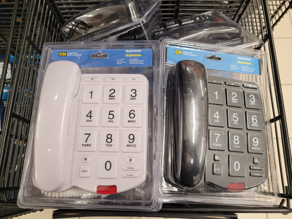 2 landline phones, one black, one white, both with absolutely enormous number buttons